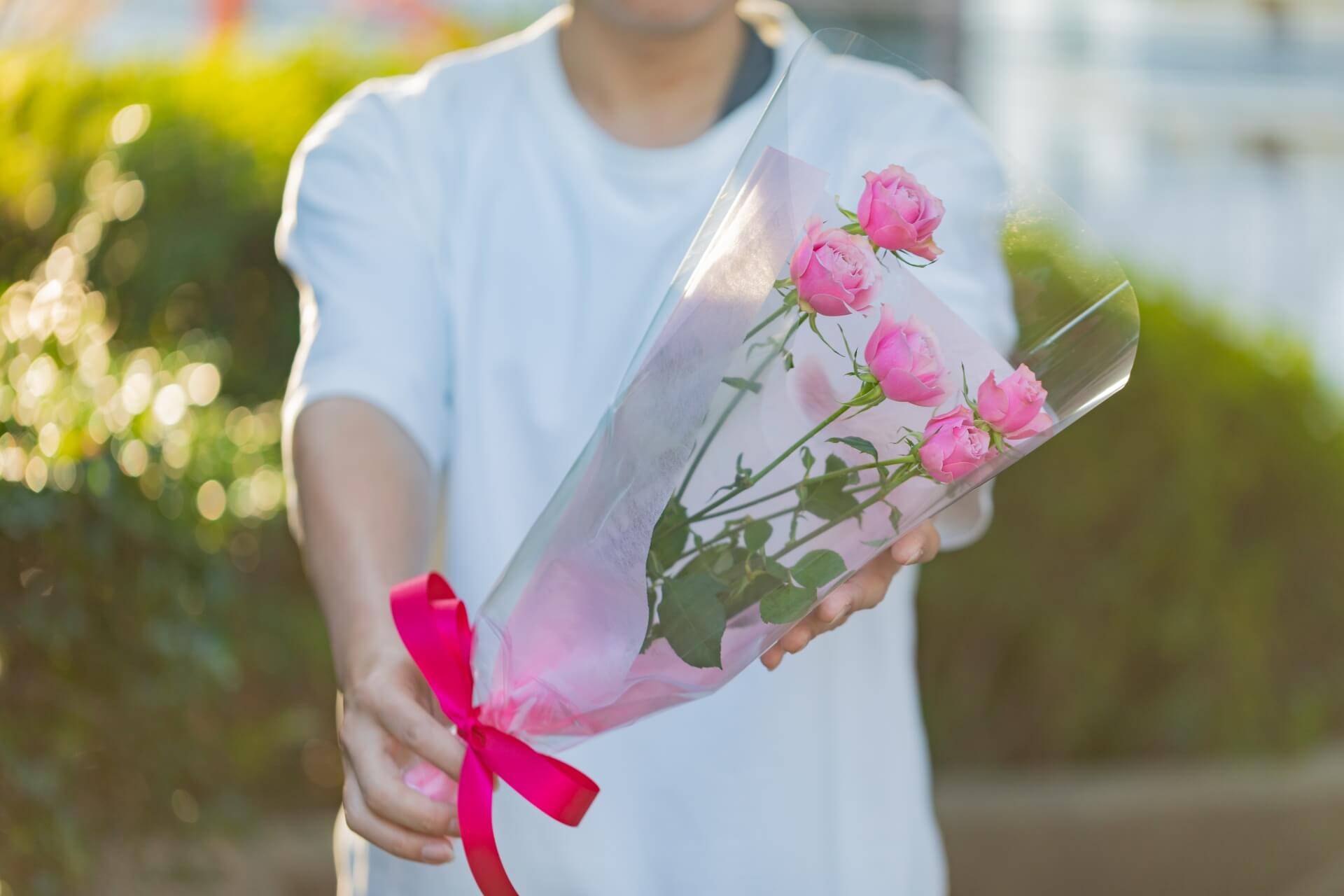 薔薇の花束をプレゼントする男性
